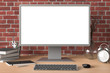 © dimamoroz - Workspace with blank computer monitor white screen mock up on the wooden desk near red brick wall. monitor; screen; computer; mock up;