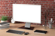 © dimamoroz - Workspace with blank computer monitor white screen mock up on the wooden desk near red brick wall. monitor; screen; computer; mock up;