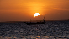 Sunset On A Beach In Zanzibar With A Boat In The Light