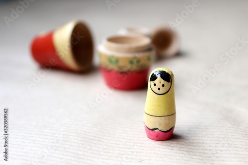 Wooden Russian matryoshka dolls in folk style, girls with painted dresses and veiled heads covered with babushka shawl. A little girl is lost, alone and frightened
