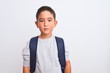 © Krakenimages.com - Beautiful student kid boy wearing backpack standing over isolated white background with serious expression on face. Simple and natural looking at the camera.
