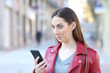 Perplexed woman checking smart phone news