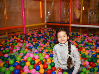 Wall Mural - little girl plays on the playground with colorful balloons