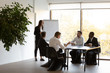 © fizkes - Woman business trainer and workers gathered together in conference room