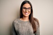 © Krakenimages.com - Young beautiful brunette woman wearing casual sweater and glasses over white background with a happy and cool smile on face. Lucky person.