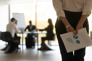 Rear view businesswoman holding financial papers ready for presentation