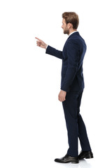 Wall Mural - young businessman in navy blue suit pointing finger to side