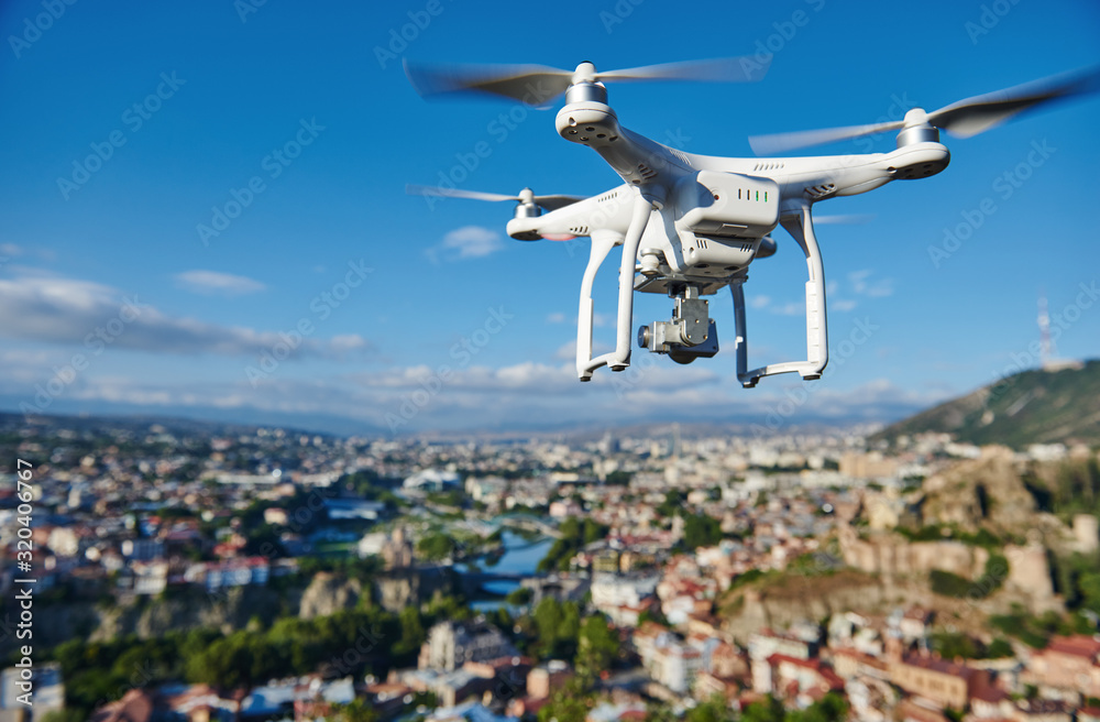 drone with digital camera hovering over city Stock Photo | Adobe Stock