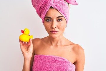 Wall Mural - Young beautiful woman wearing shower towel holding duck over isolated white background with a confident expression on smart face thinking serious