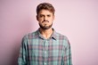 © Krakenimages.com - Young handsome man with beard wearing casual shirt standing over pink background puffing cheeks with funny face. Mouth inflated with air, crazy expression.