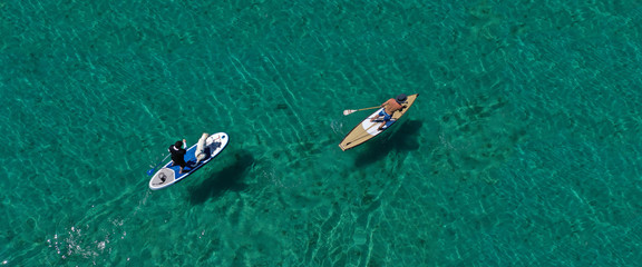 Wall Mural - Aerial drone ultra wide photo of friends practising in SUP or Stand Up Paddle in tropical exotic bay with turquoise sea