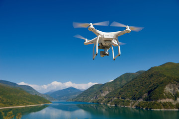Wall Mural - uav drone with digital camera over lake in mountains