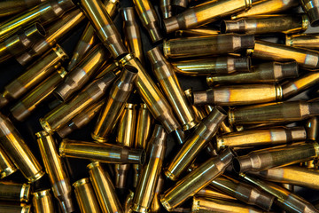 Wall Mural - Background from empty cartridges for rifles and carbines. Shiny brass shells scattered on the surface.