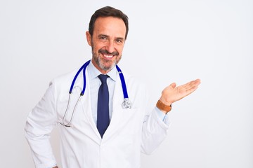 Middle age doctor man wearing coat and stethoscope standing over isolated white background smiling cheerful presenting and pointing with palm of hand looking at the camera.