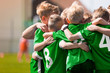 © matimix - Happy Sports Boys in a School Team. Kids Huddling in a Team on Tournament Competition Before the Final Match. Players Gathering Together in a Circle to Strategize and Motivate