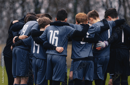 Fotografía Soccer team with junior coach gathering together in a circle, to strategize and motivate