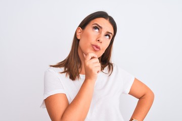 Sticker - Portrait of beautiful and young brunette woman standing over isolated white background with hand on chin thinking about question, pensive expression. Smiling with thoughtful face. Doubt concept.