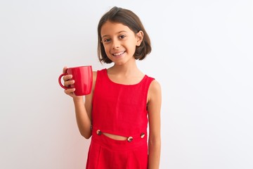 Poster - Beautiful child girl holding red cup of tea standing over isolated white background with a happy face standing and smiling with a confident smile showing teeth