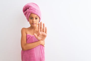 Poster - Beautiful child girl wearing shower towel after bath standing over isolated white background doing stop sing with palm of the hand. Warning expression with negative and serious gesture on the face.