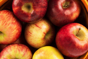 Wall Mural - Apples basket disposed on a wooden table. Flat lay, top view of autumn decoration concept.
