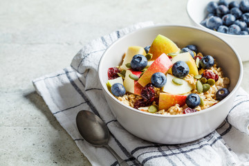 Wall Mural - Bircher muesli or overnight oatmeal with apple, banana and blueberries in gray bowl.