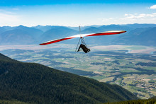 Long Shot Of Flying Extremal Hang Glider. Young Man Enjoying His Recreational Journey To Creston, British Columbia, Canada