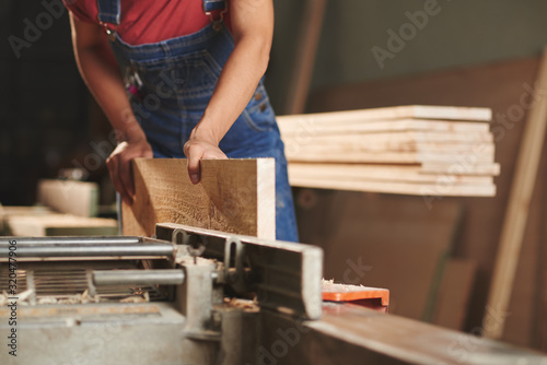 Fotomural Close-up view of unrecognizable carpenter in denim overall processing wooden boa