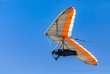 Hang Glider flying in the sky on a sunny day. Recreational activities during the summer holidays. Soaring flight of hang gliding
