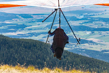 Professional Hang Glider Man Taking Off From The Mountain Top. Hang Gliding In Action. Soaring Flight Of Hang Glider Pilot