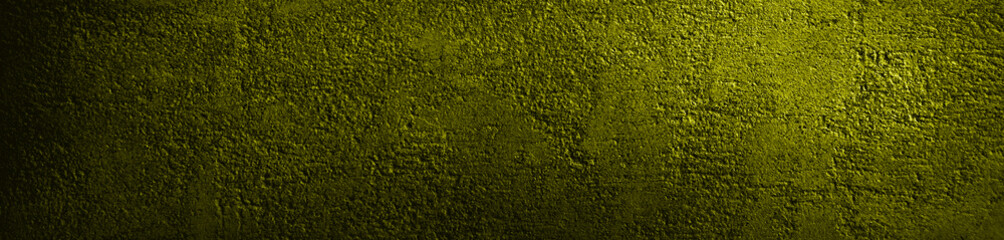 Green yellow grunge background. Texture of painted concrete wall closeup. Rough surface in reflection of light. Dirty green color banner with copy space.