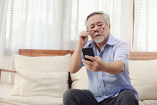 Older Men Move Glasses Down To Look At The Phone In The Hand Due To Hyperopia Problems, Which Makes Vision Difficult.Health Problems Of The Elderly.