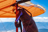 Man preparing to fly in a hang gliding. The professional pilot of hang-glider getting ready to fly from the top of mountain hill