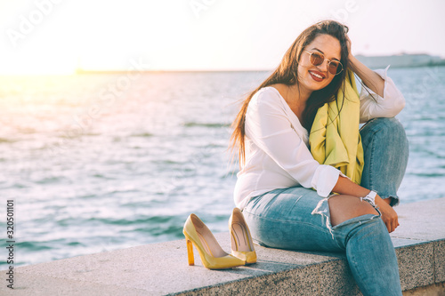 Fotomural Happy plus size model taking off shoes and relaxing on city street