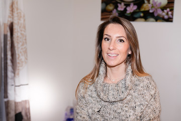 Happy woman posing near sofa in the living room at home