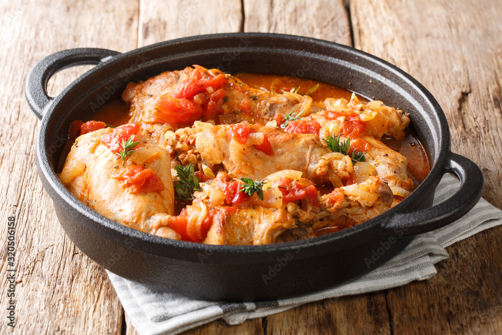 Obraz na płótnie Tasty spicy rabbit stew in tomato sauce with white wine and herbs close-up in a pan. horizontal w salonie