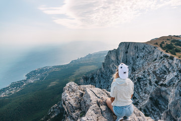 Wall Mural - Man traveler sitting on mountain and looking at beautiful landscape and sea.