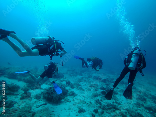 Scuba divers under water. Bubbles, blue water, Zanzibar