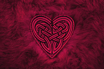 Valentine heart, symbol for love and friendship. Celtic heart lies on a fur rug