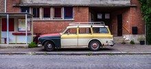 Vintage Classic Station Wagon With Mismatched Panels Parked On Side Of Neighborhood Road