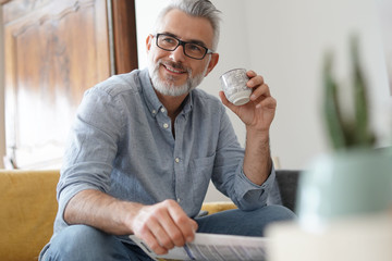 Man at home sitting in sofa having hot coffee