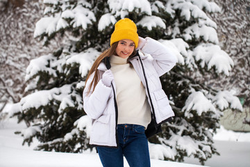 Wall Mural - Portrait of a young happy woman on a background of a winter park