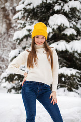 Wall Mural - Portrait of a young happy woman on a background of a winter park