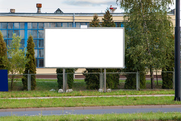 Blank advertising billboard mockup in front of industrial building