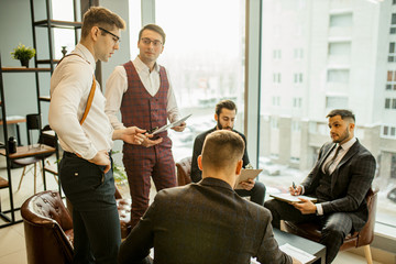 Wall Mural - young confident men developing new business startup, discussing interaction in finance and market, sharing opinions and ideas with each other, dressed in formal wear. success, business concept