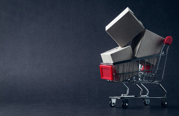 Shopping cart and box on dark background, business, shopping concept. Selective focus