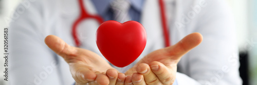 Fotografía Male medicine doctor hands holding and covering red toy heart