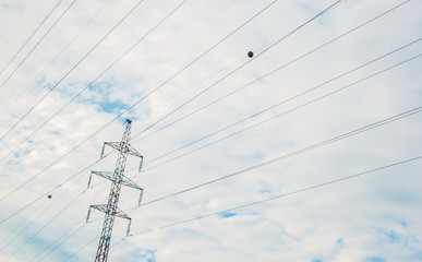 High voltage electric transmission pylon silhouetted. Electricity transmission pylon silhouetted against blue sky. High voltage electric tower in the blue sky background, side view.