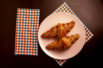 two whole wheat croissants on a pink plate