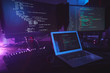 Background image of various computer equipment with programming code on screens on table in dark room, cyber security concept, copy space