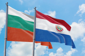 Paraguay and Bulgaria flags waving in the wind against white cloudy blue sky together. Diplomacy concept, international relations.